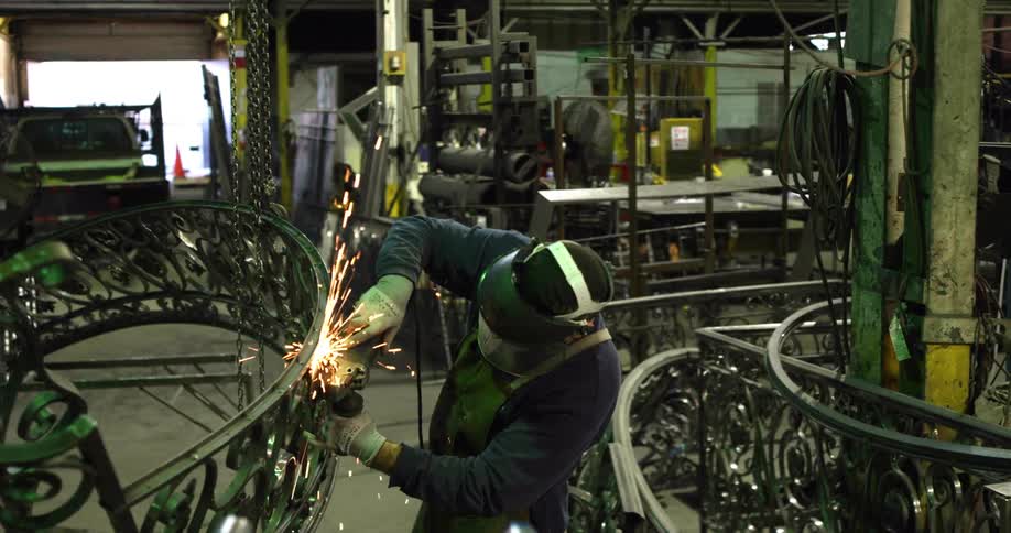 Sparks fly as a man welds in a factory
