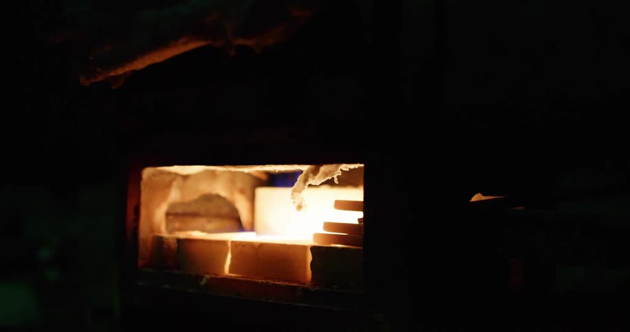A furnace glows bright in a dark basement