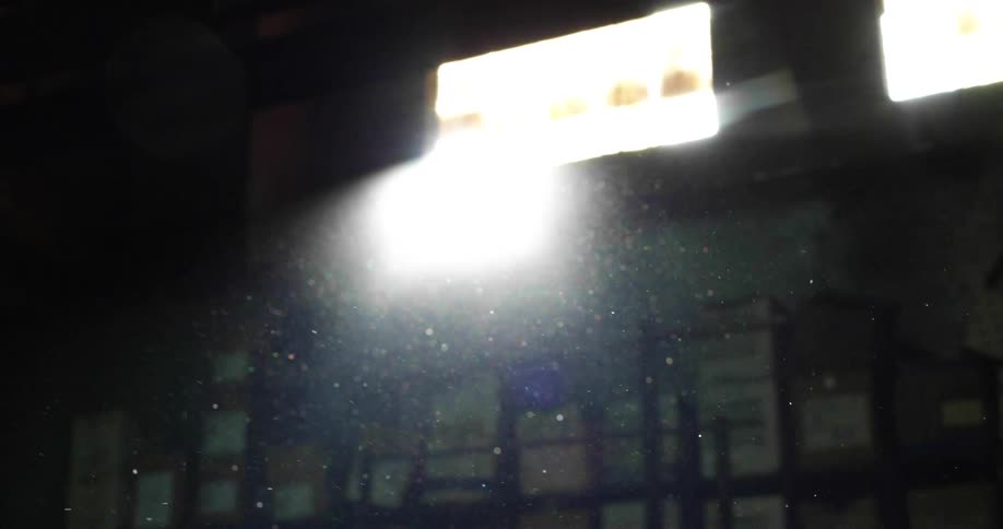 Light shines brightly through window over boxes stored on shelves as sparks fly into air