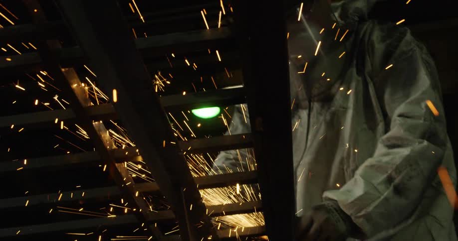 Sparks fly as a man in a factory welds