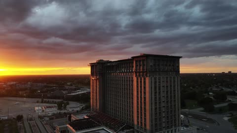 A large building under a dark cloudy sky at sunset