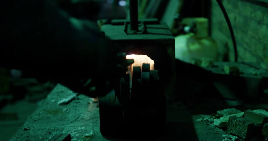 A man in a factory heats up steel in a fire
