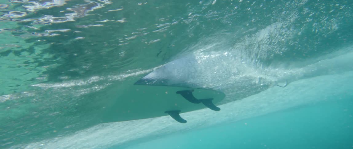 Underwater shots of a surfer gliding on wave