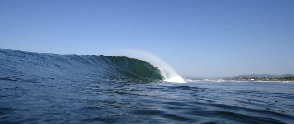 Waves in the ocean near a beach and trees