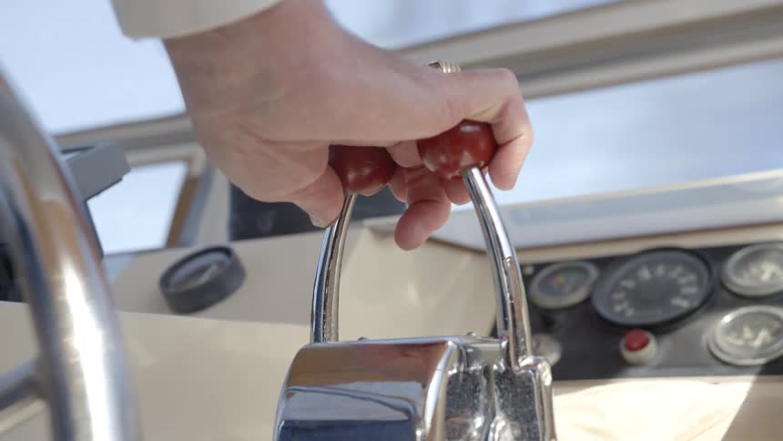 Close up of a mans hand as he drives a boat