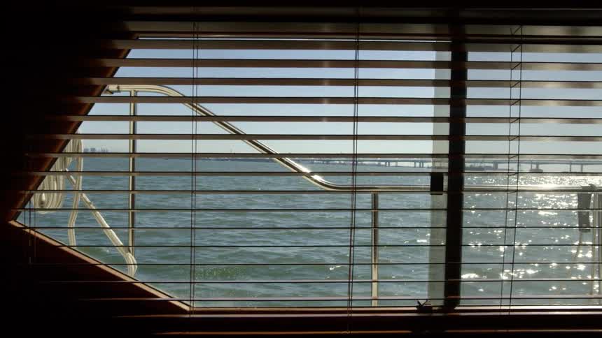 A view from inside a boat as it sails past a pier