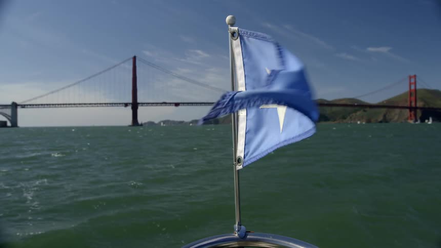 A blue flag on a boat flaps in the breeze
