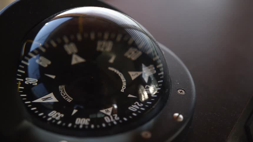 Small compass attached to black surface