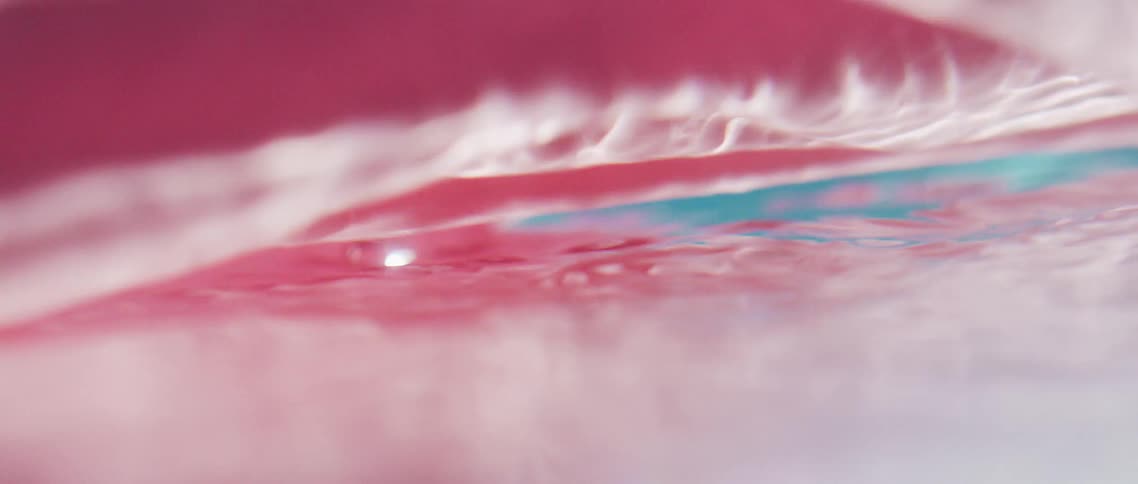 Colorful fabric floats and spins through water highlighted with bright light