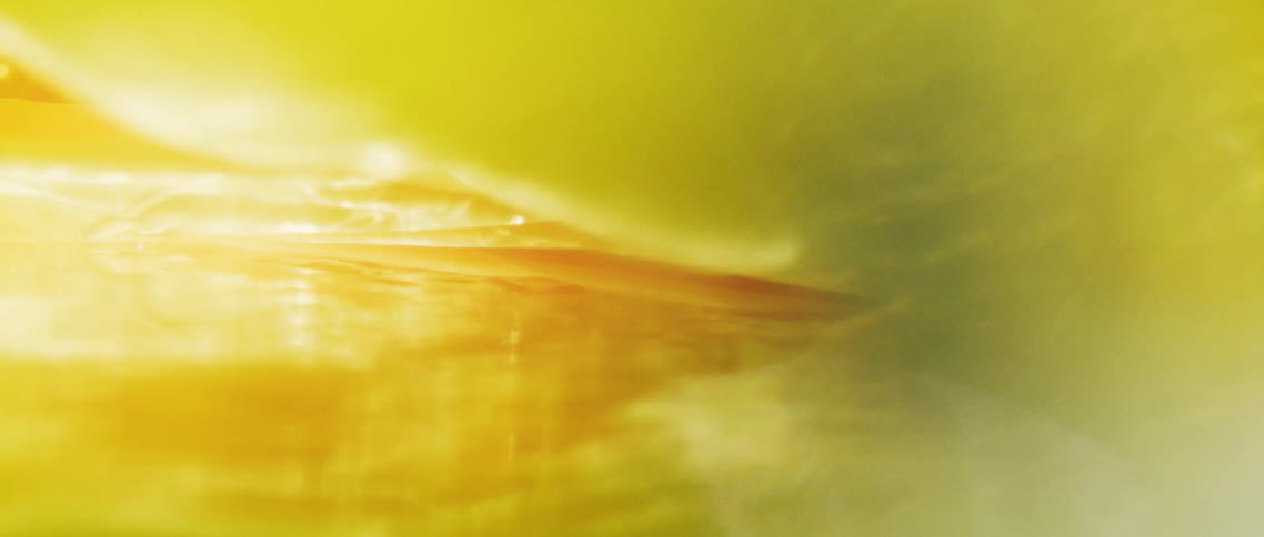 Yellow fabric spins and separates as its floats underwater in a pool