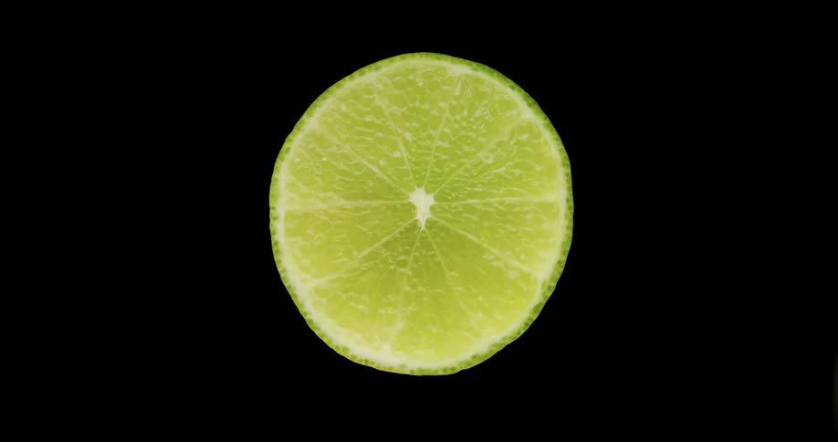 A knife slices through a lime