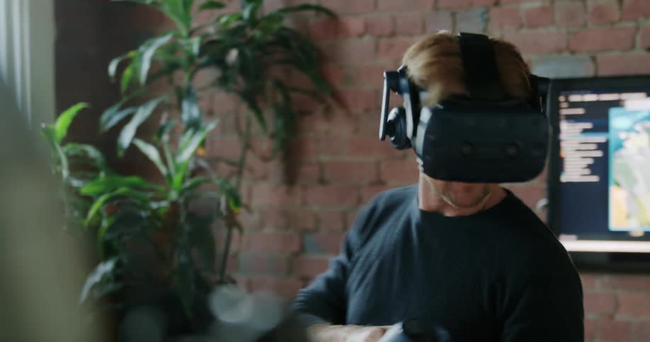 A man wears a virtual reality headset and plays a game