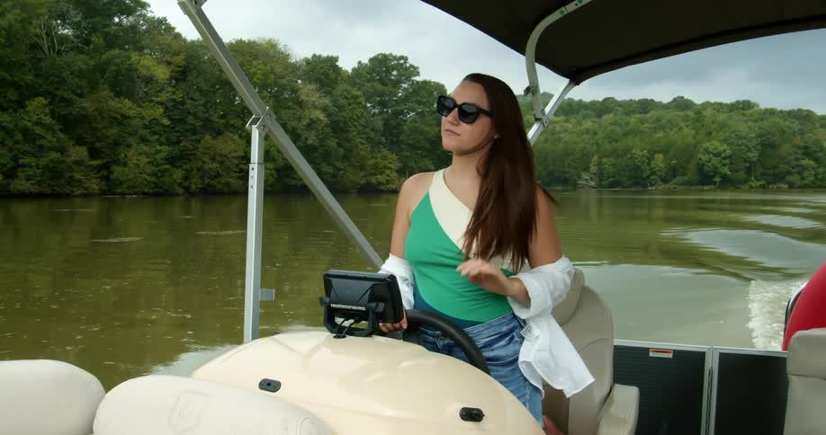 Woman driving motor boat across lake