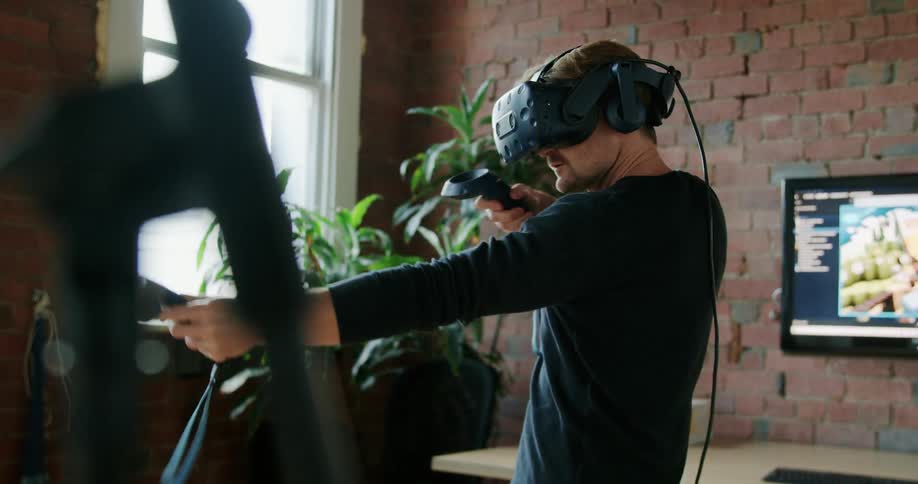 A man plays a video game using a virtual reality headset at home