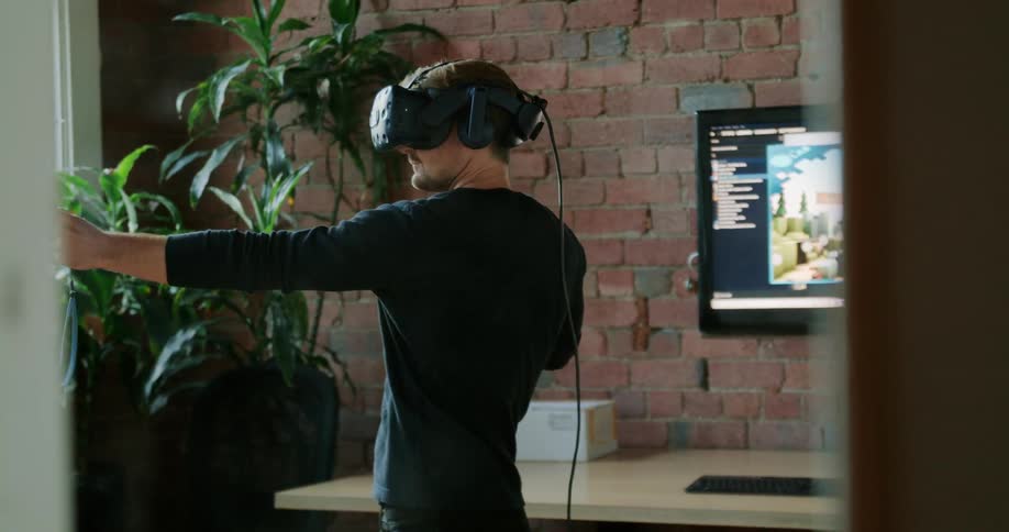 A man plays a virtual reality game using a virtual reality headset