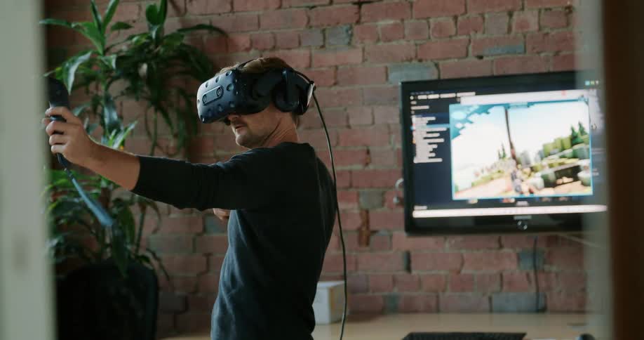 A man wearing a virtual reality headset plays a vr game