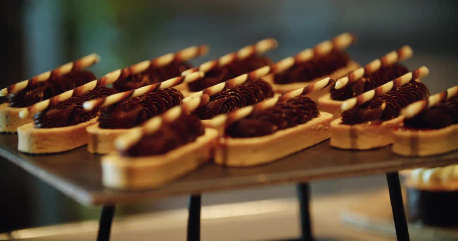 Cookies that are decorated sitting on a stand on a table