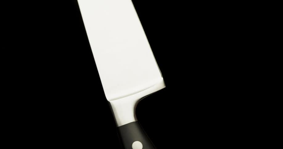 Sharp knife falls down on the ground on the black background
