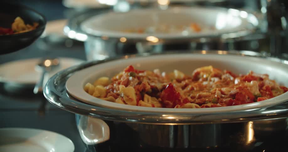 A woman at a buffet puts food on her plate