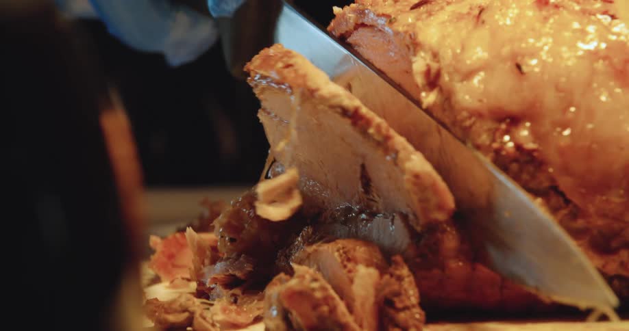 Large cut of meat being sliced on cutting board