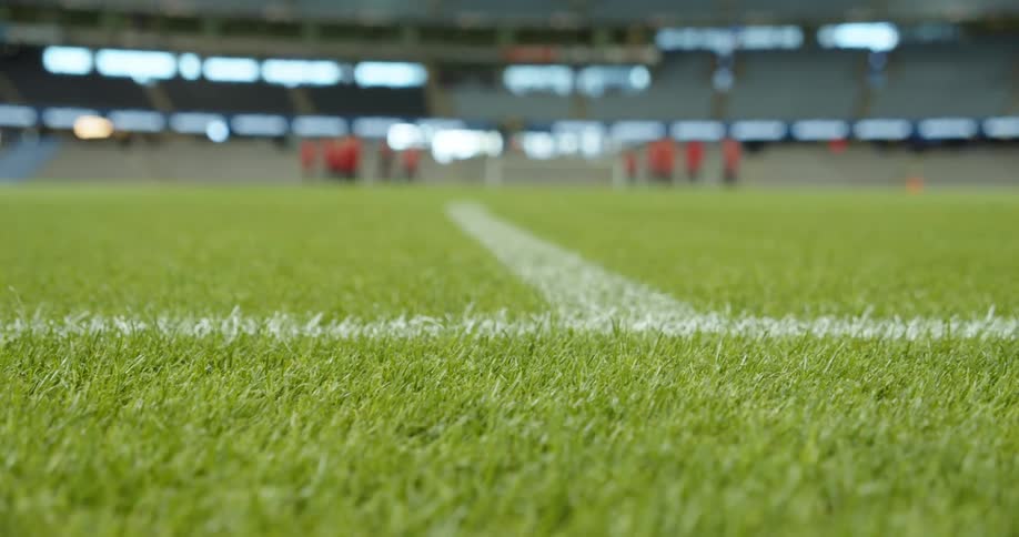 A team standing on an outdoor field in a stadium