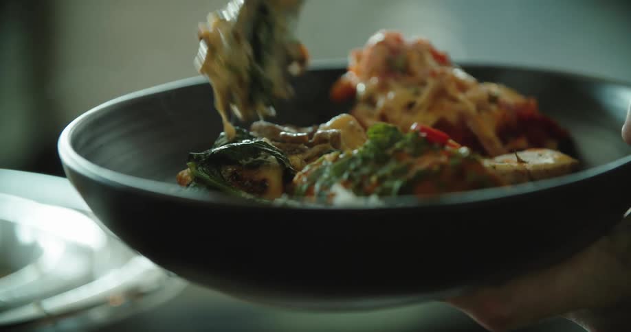A person serves food up on to a plate