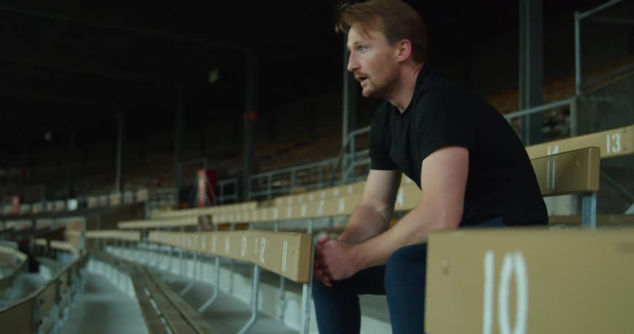 A white man takes a breather while sitting on a stadium seat