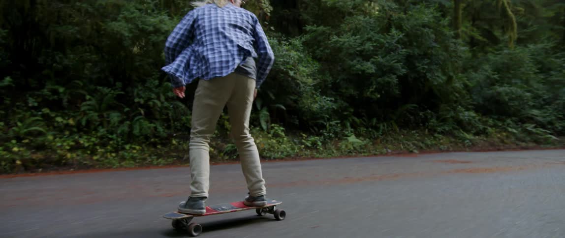 A man skateboards on a road