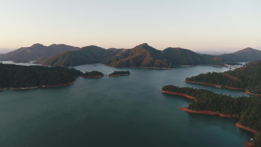 An aerial view of a lake surrounded by mountains in nature