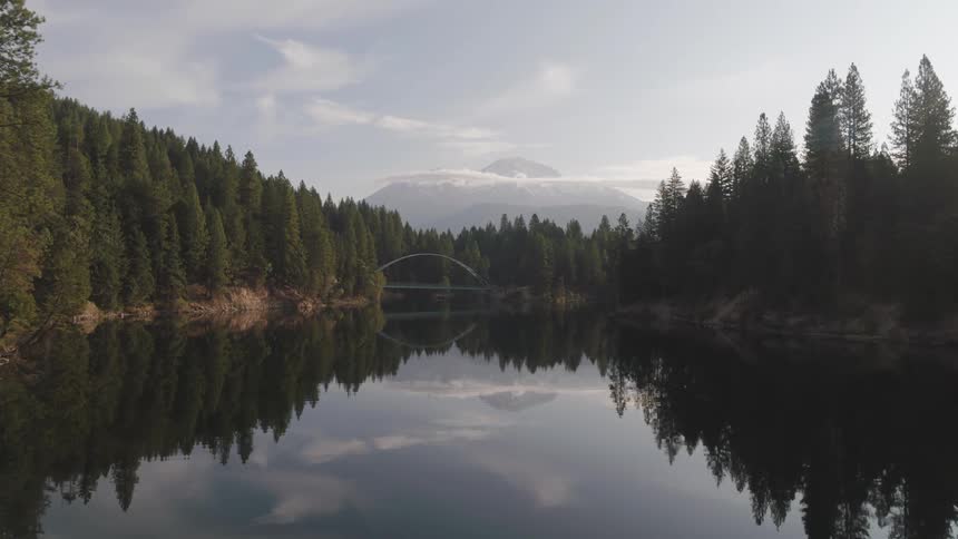 Landscape view of a forest and lake with a mountain range in the distance