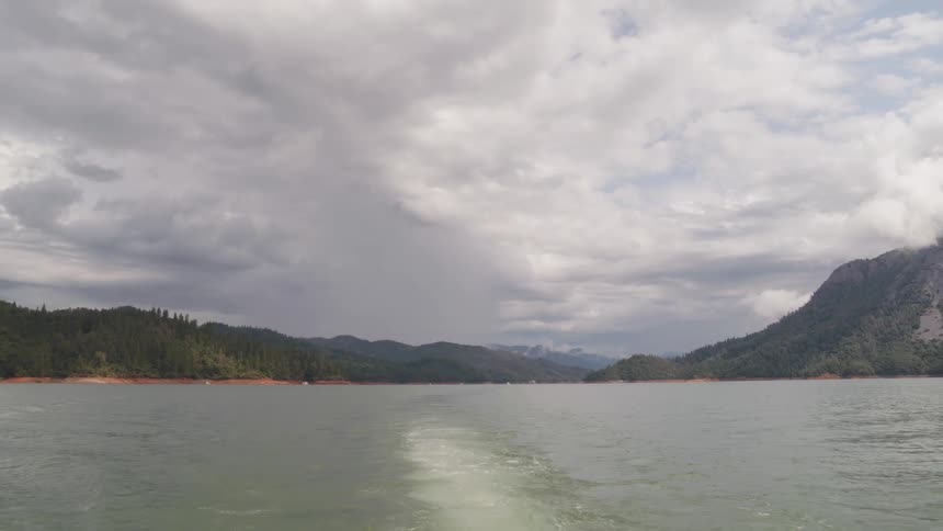 Landscape view of a lake with a forest and mountain in the distance