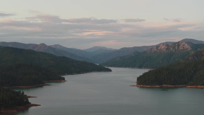 Clouds float above a mountain lake at sunset