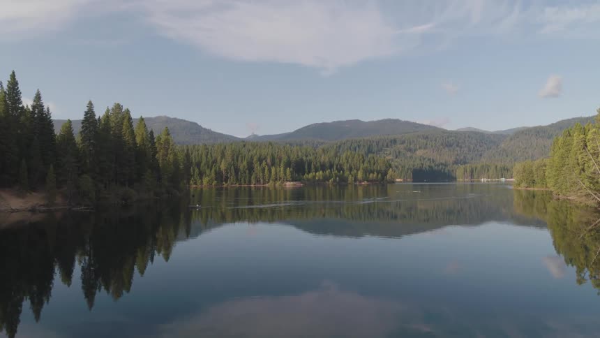 View of a tranquil lake with mountain forests in the background