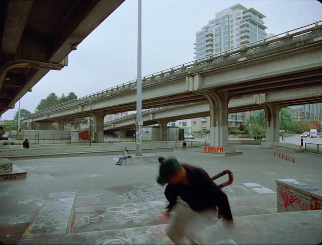 A group of people use skateboards around an outdoor city skate park