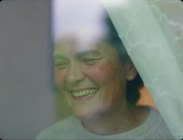A woman is waving from the window