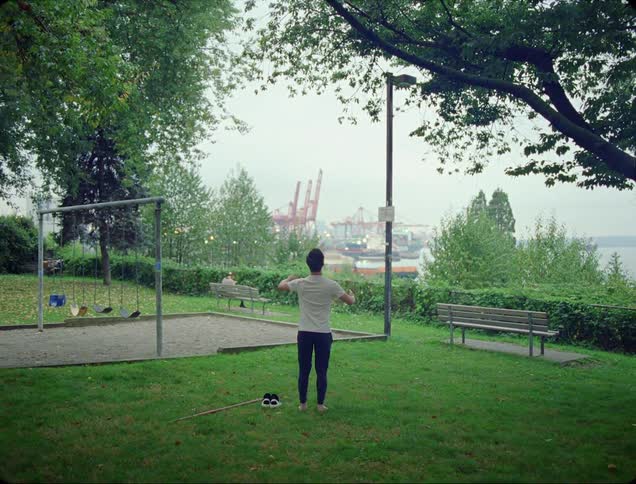 A man stands frozen in the park