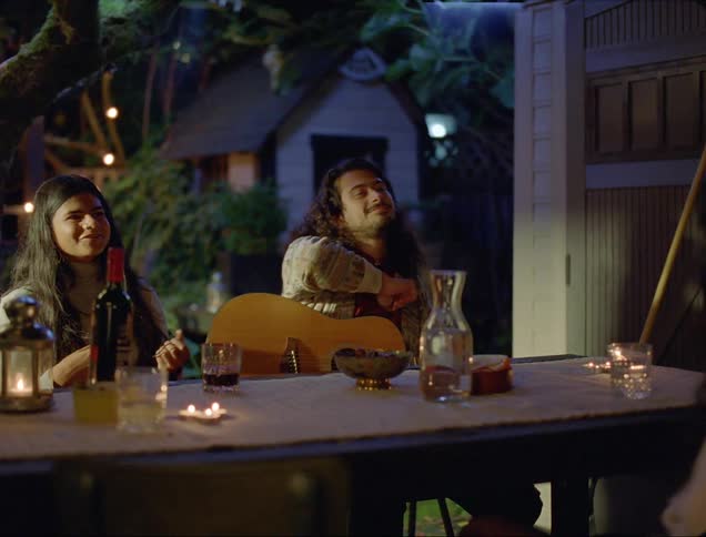 Group of friends sitting at outdoor table talking and smiling