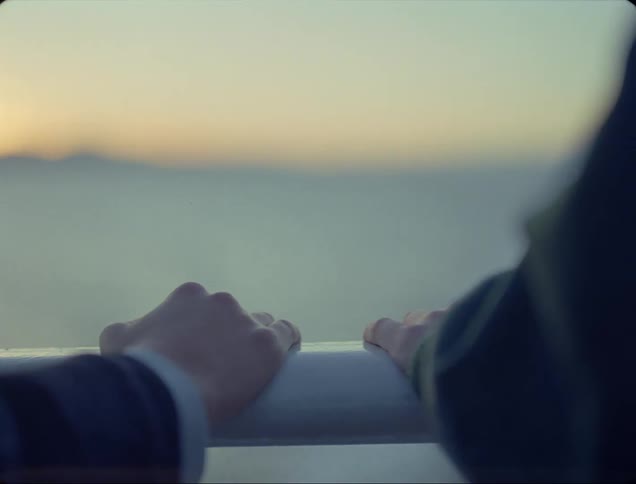 Two people stand by the railing together