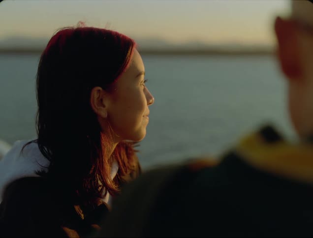 Two people standing near a lake