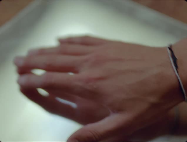 Person raises and lowers hand over mirror reflecting hand