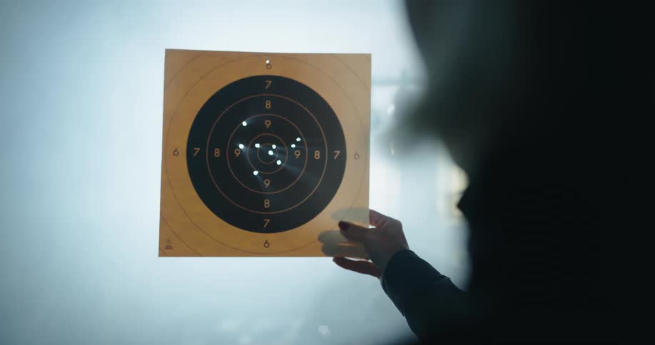 A person examines the shots fired into a target
