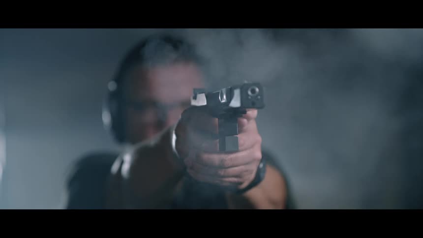 A man shooting a gun indoors