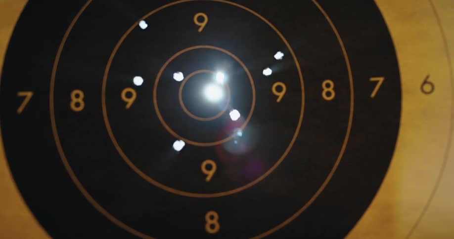 Sunlight shines through the holes of a paper shooting target