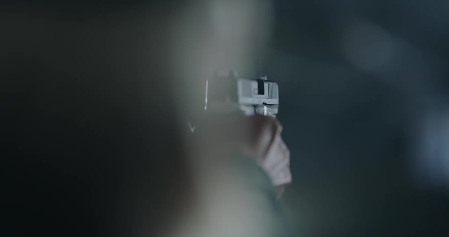 A white person raises a gun and aims it