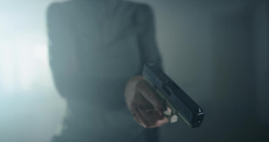 A woman picks up a gun and loads it and aims