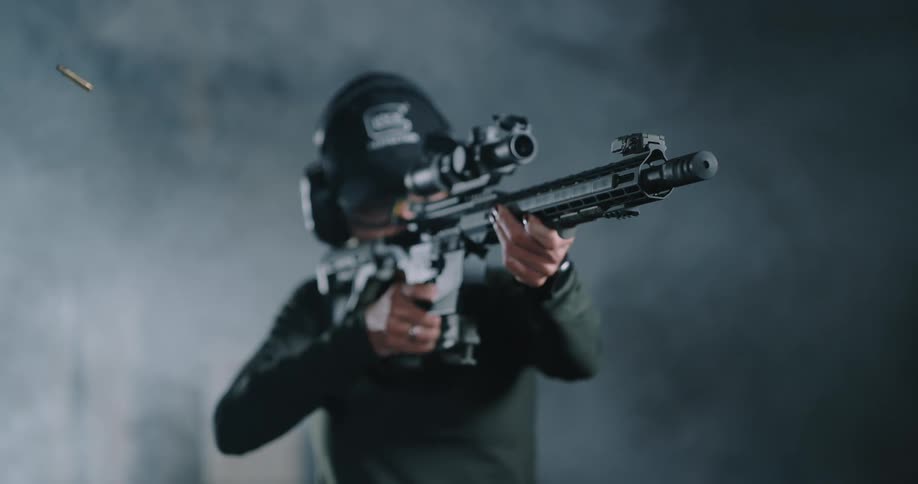 A woman fires a large scoped rifle