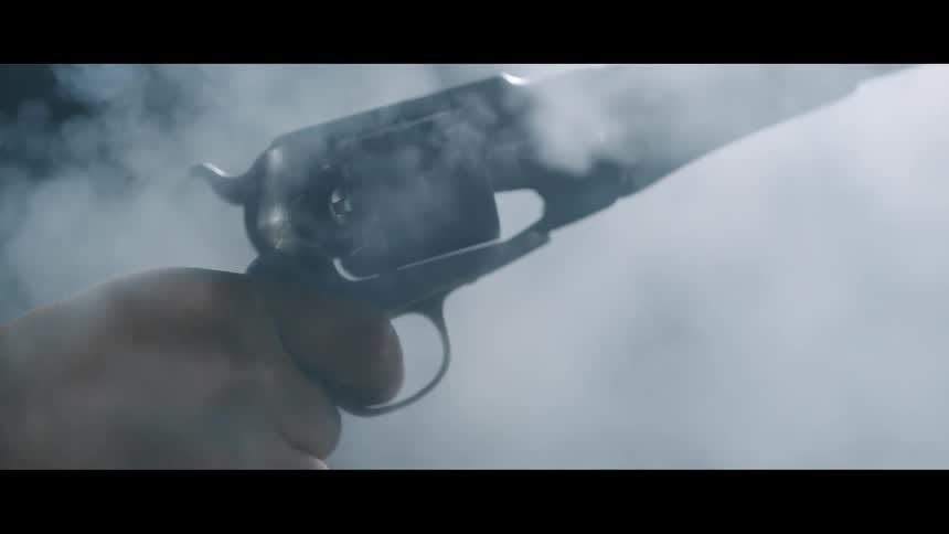 A person is holding a gun and shooting it