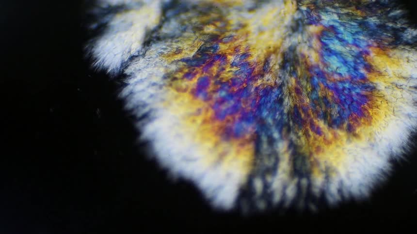 Colorful crystals reflection bright colors expanding formation on a black surface