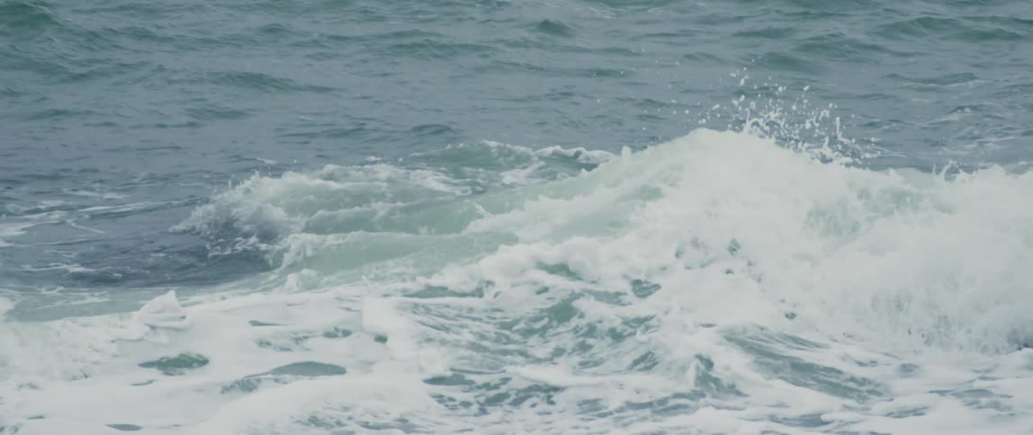 The winter sea churns with foam and sea spray