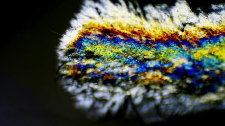 Colorful crystals spreading over a black surface